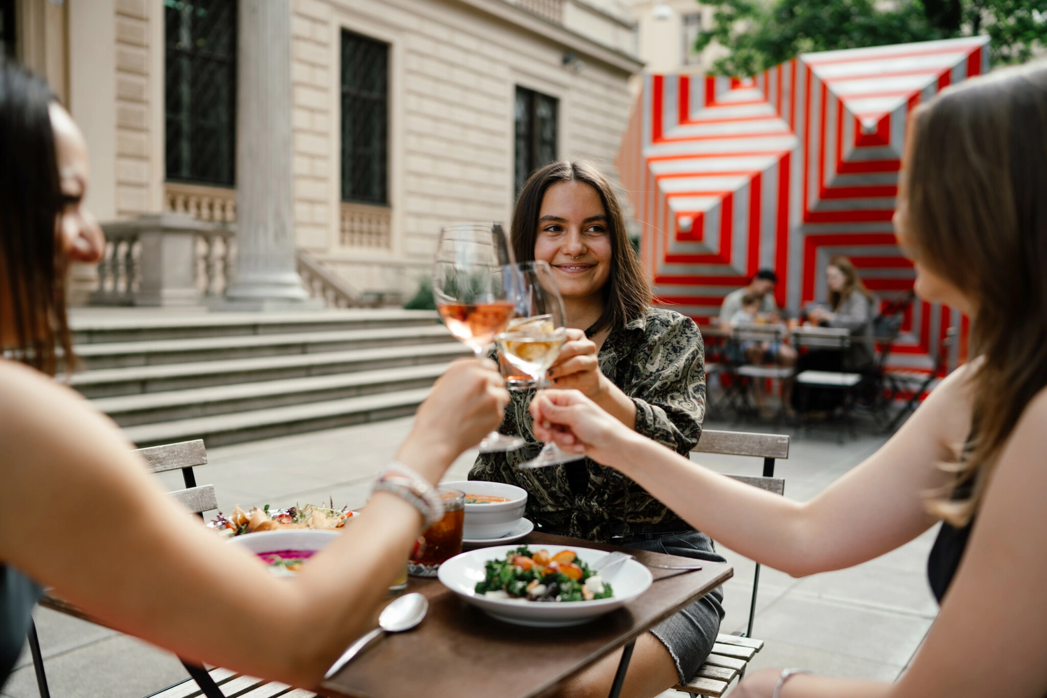 Divky-si-pritukavaji-sklenici-vina-v-mestskem-venkovnim-baru-v-podrousenem-stavu