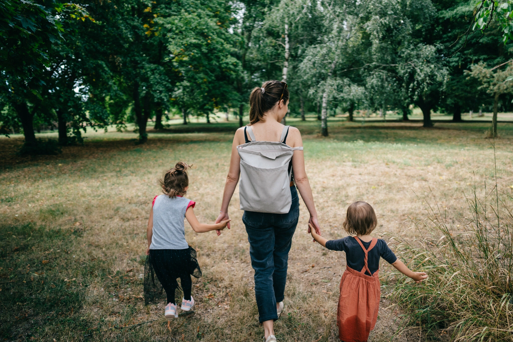 Maminka-v-parku-drzi-cizi-deti-za-ruce-a-unasi-je-pryc